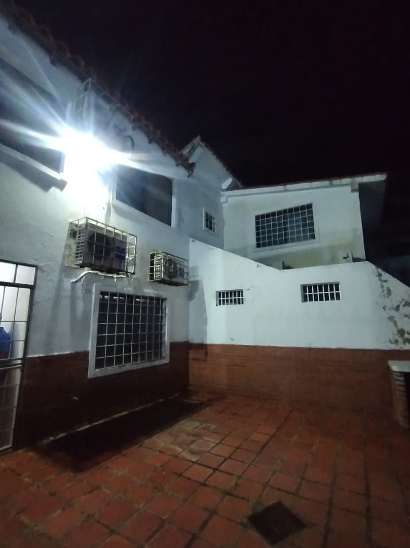 Zona exterior techada con mesas y área de parrilla