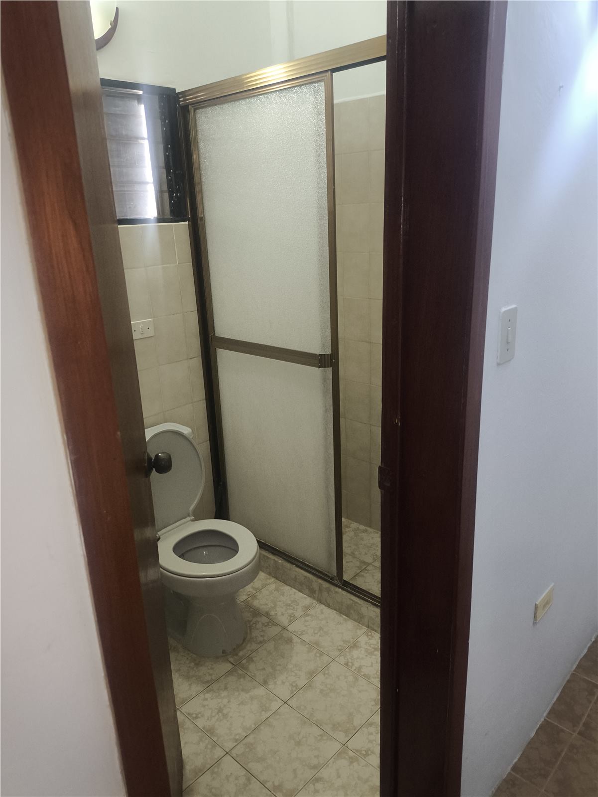 Baño interior con ducha cerrada y cerámica clara