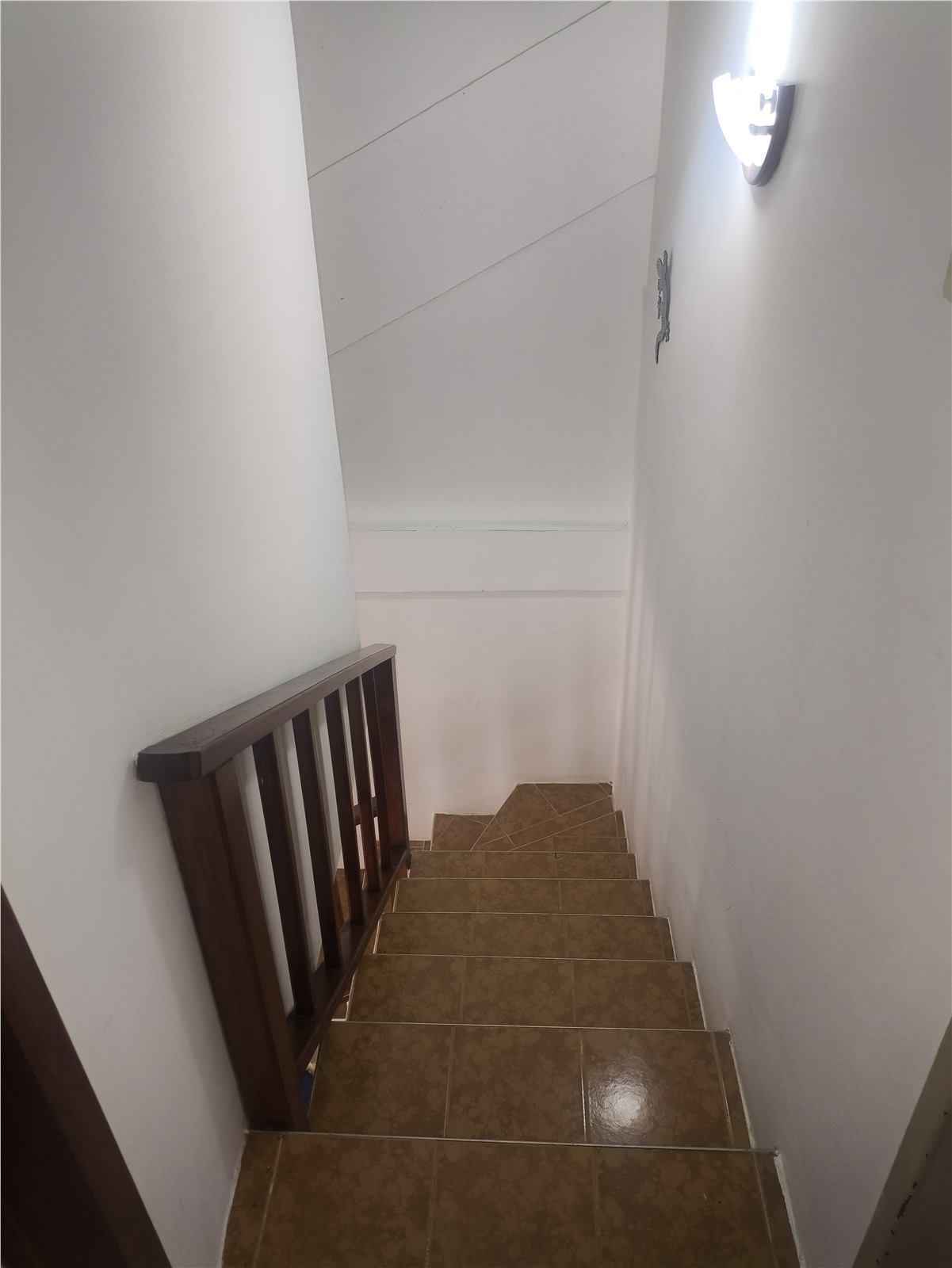 Escalera interior del townhouse con baranda de madera